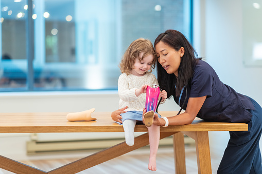 Doctor assisting a young patient with a leg prosthetic.